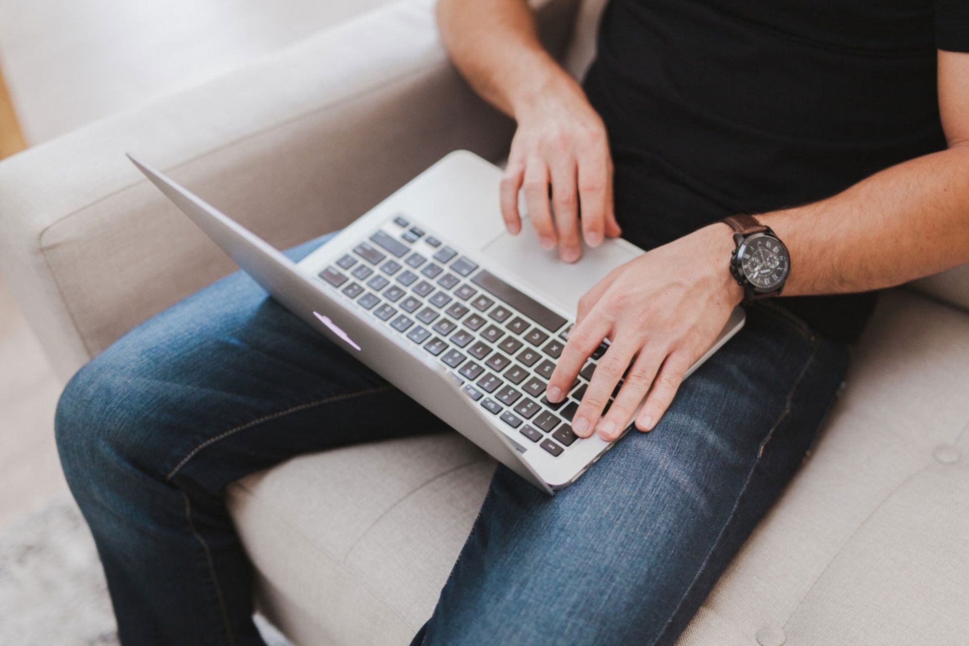 A person using a laptop on the sofa