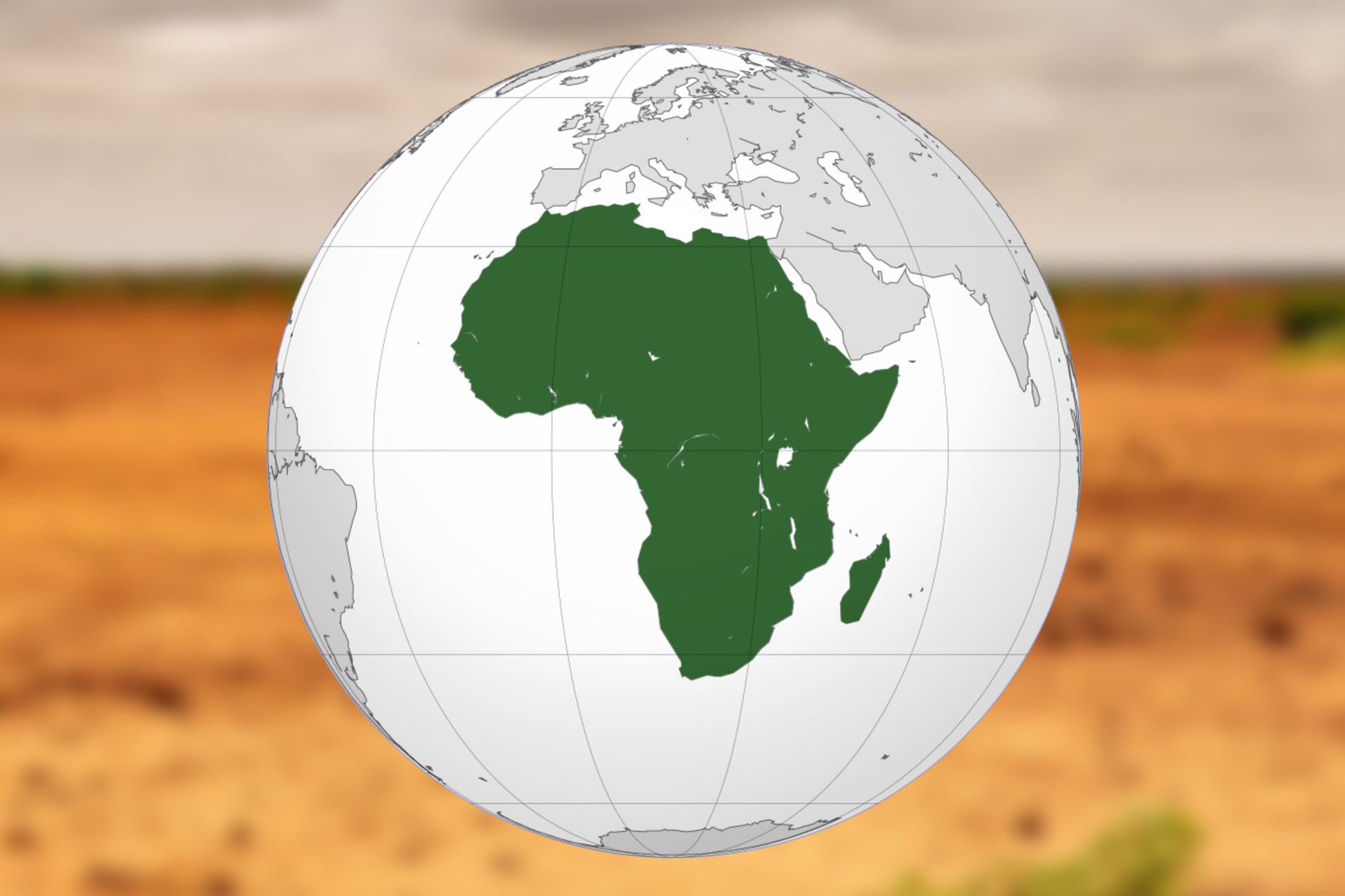 A photo of a white globe with a country in green on a matte desert image