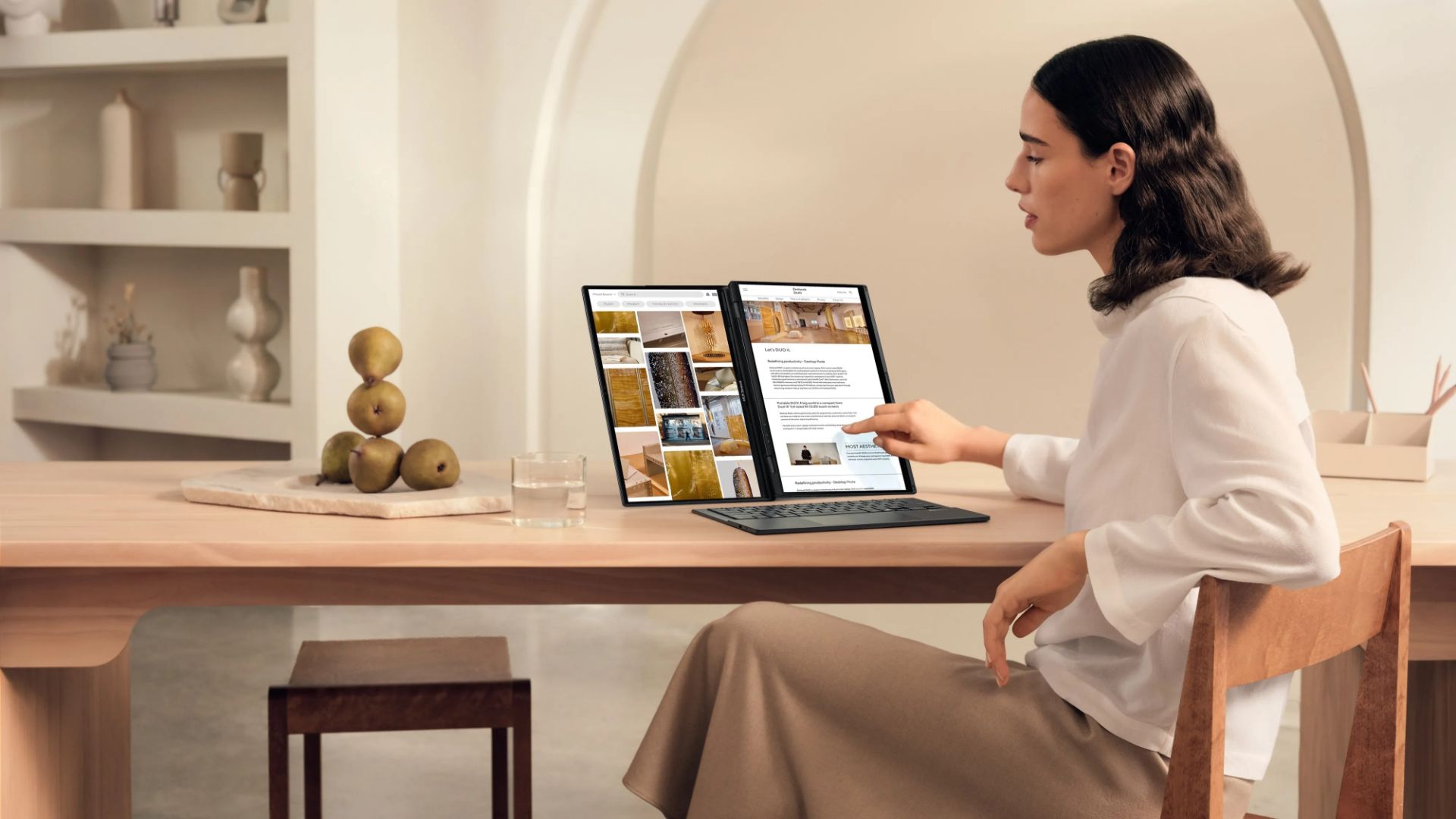 A young woman working with an Asus Zenbook Duo laptop